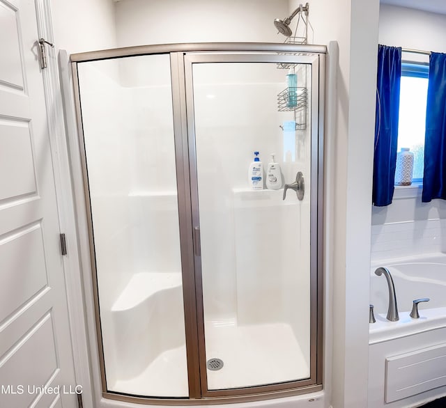 bathroom featuring a stall shower and a garden tub