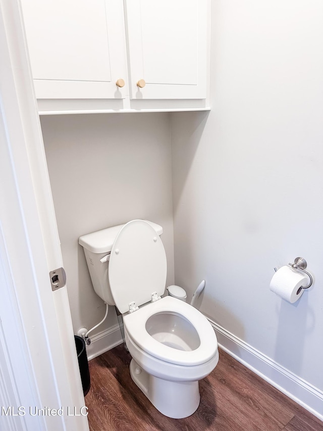 bathroom featuring toilet, baseboards, and wood finished floors