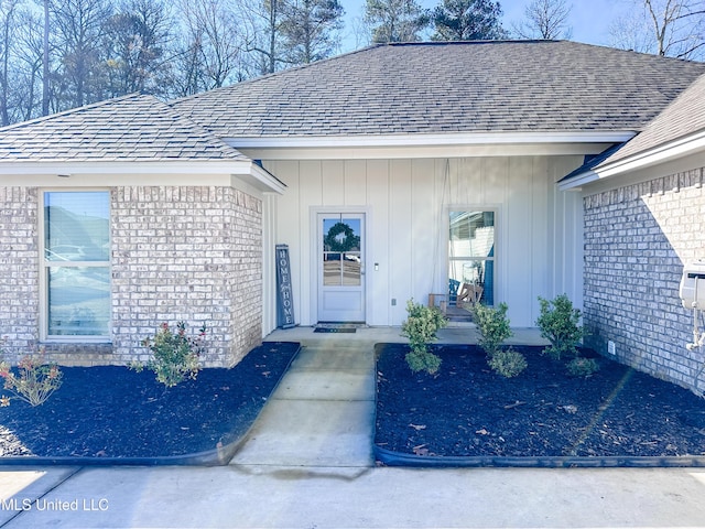 entrance to property featuring board and batten siding, covered porch, and brick siding