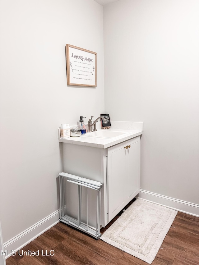 bathroom with wood finished floors, vanity, and baseboards