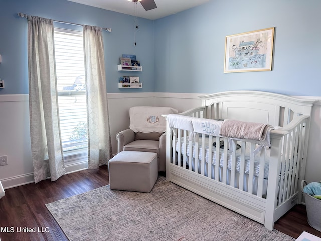 bedroom featuring a crib and wood finished floors