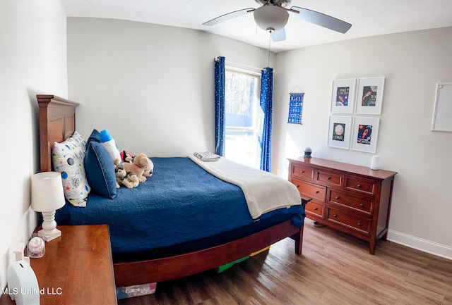 bedroom featuring ceiling fan, wood finished floors, and baseboards