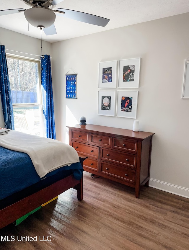 bedroom with wood finished floors, a ceiling fan, and baseboards