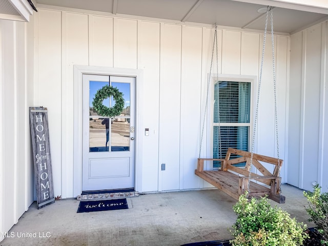 entrance to property with covered porch and board and batten siding