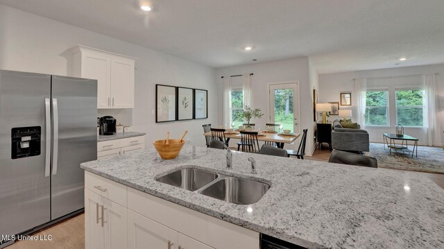 96 Twin Lakes Dr, Byhalia, MS 38611 - kitchen featuring stainless steel refrigerator with ice dispenser, light wood finished floors, light stone countertops, white cabinets, and open floor plan