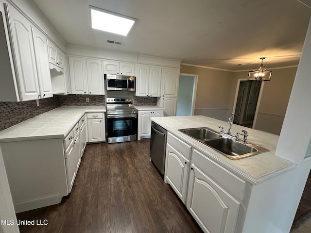 365 Gatewood Dr, Pearl, MS 39208 - kitchen featuring appliances with stainless steel finishes, a sink, dark wood-style floors, white cabinets, and backsplash