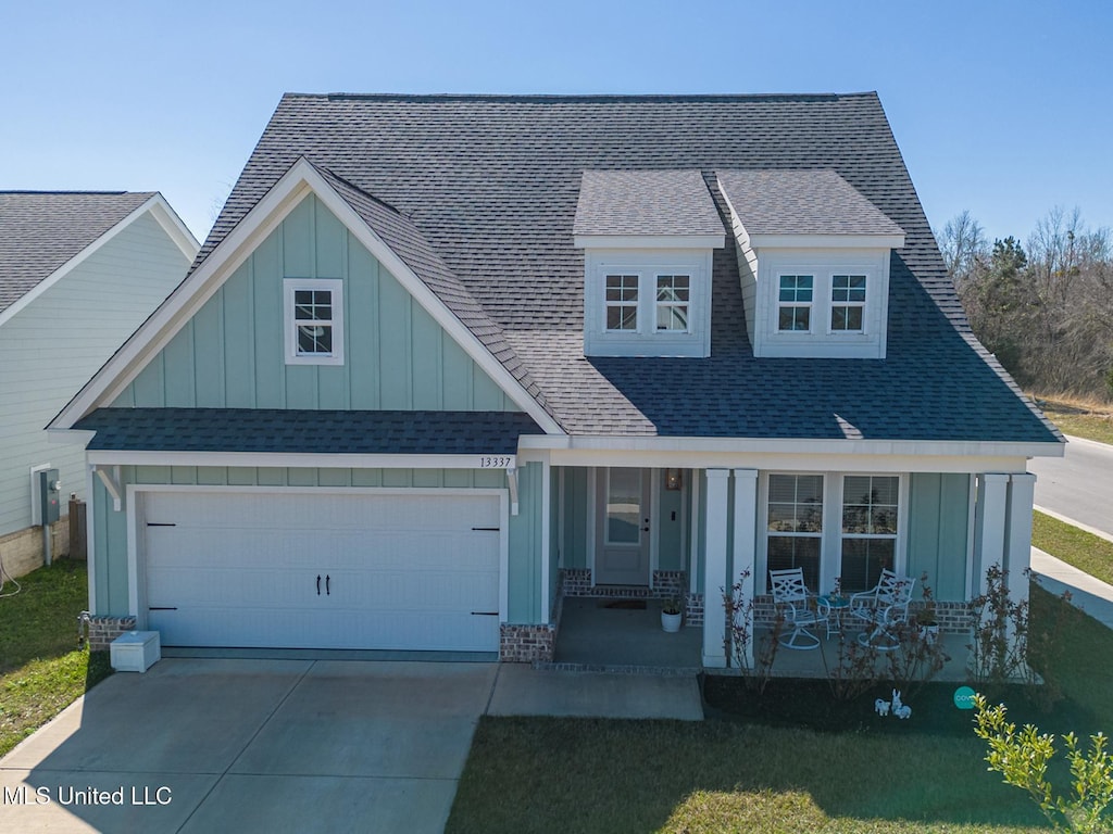 13337 Hawk Pl, Gulfport, MS 39503 - view of front of house with an attached garage, board and batten siding, a porch, and concrete driveway