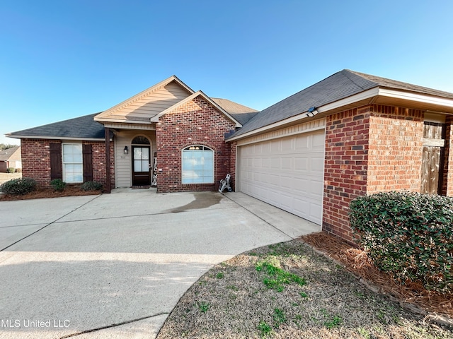 single story home featuring brick siding, an attached garage, and driveway