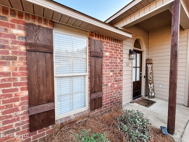 property entrance featuring brick siding