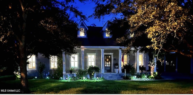 view of front of property with a porch, a front yard, and stucco siding