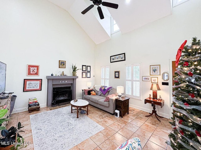 living room with ceiling fan, high vaulted ceiling, light tile patterned floors, a fireplace with flush hearth, and baseboards