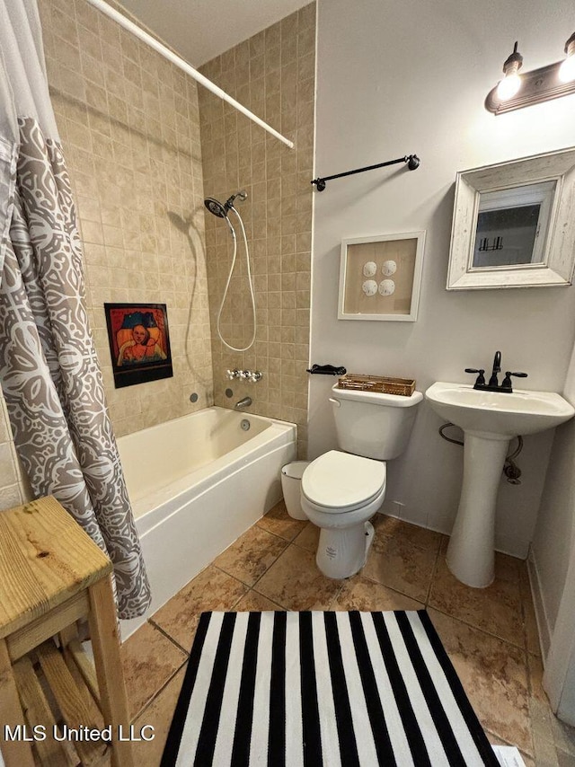 bathroom with toilet, a sink, baseboards, and shower / bath combination with curtain