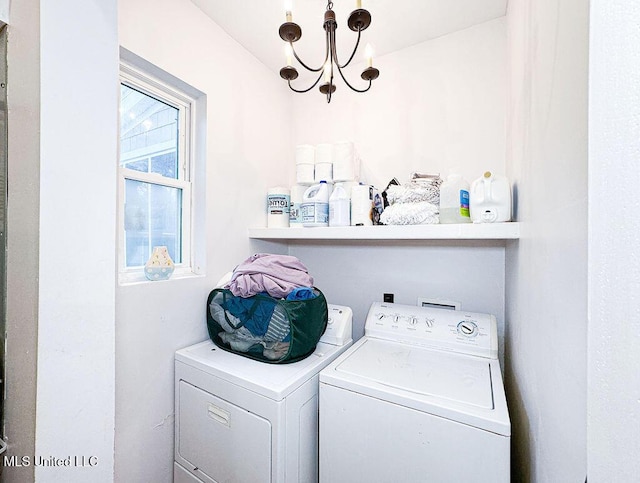 washroom featuring laundry area, a notable chandelier, and washing machine and clothes dryer