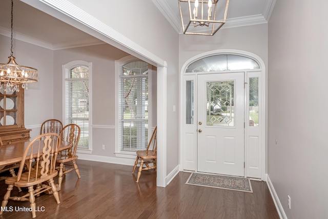 foyer with a chandelier, dark hardwood / wood-style floors, and crown molding