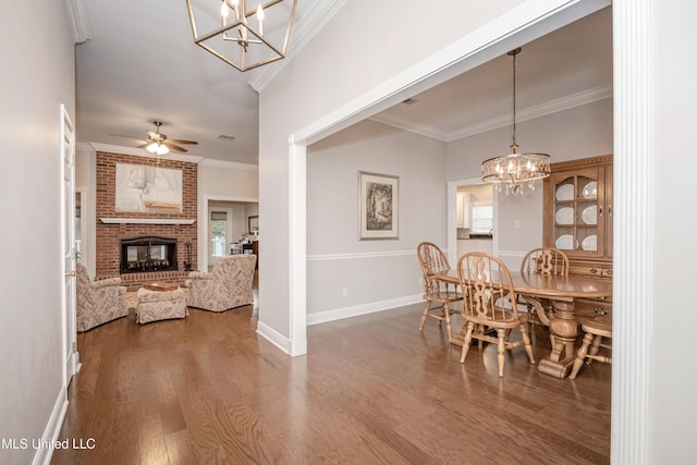 3607 Dijon Ave, Ocean Springs, MS 39564 - dining space with a chandelier, wood finished floors, ornamental molding, a fireplace, and a ceiling fan