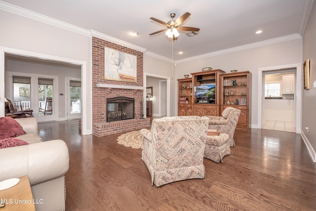 living room with a fireplace, dark hardwood / wood-style flooring, ceiling fan, and crown molding