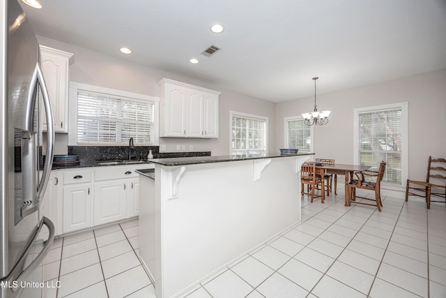 kitchen with white cabinetry, stainless steel fridge with ice dispenser, a healthy amount of sunlight, and a center island