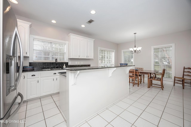 3607 Dijon Ave, Ocean Springs, MS 39564 - kitchen with stainless steel refrigerator with ice dispenser, a sink, a breakfast bar, a chandelier, and white cabinets