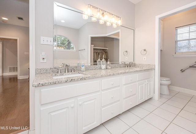 bathroom with toilet, vanity, and tile patterned flooring