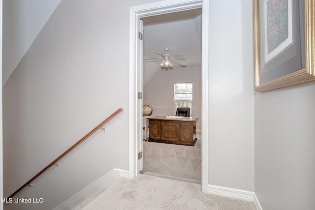 staircase featuring ceiling fan, vaulted ceiling, and carpet