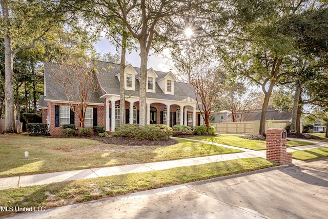 cape cod house with a front lawn and a porch