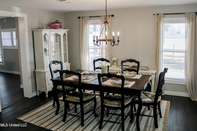 dining room featuring a wealth of natural light, dark wood-type flooring, and a chandelier