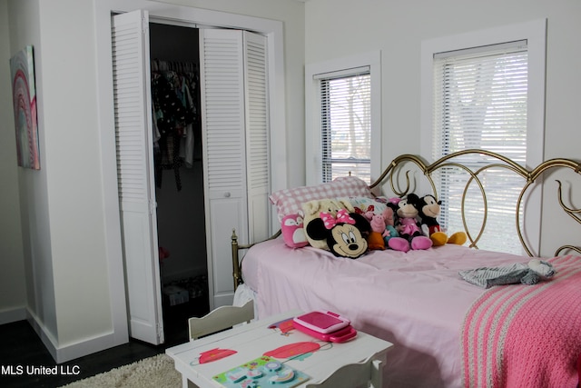 bedroom with a closet and dark wood-type flooring