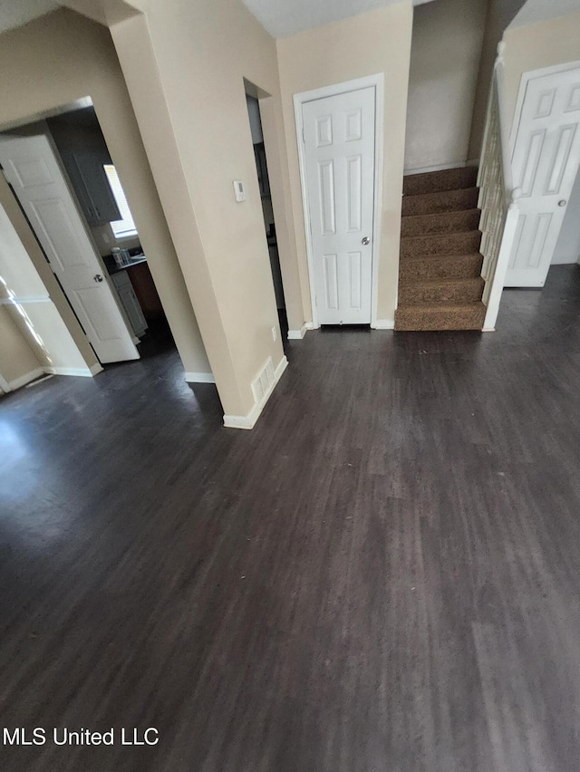10101 Stephenson Ln, Olive Branch, MS 38654 - unfurnished living room featuring dark wood-style flooring and stairs