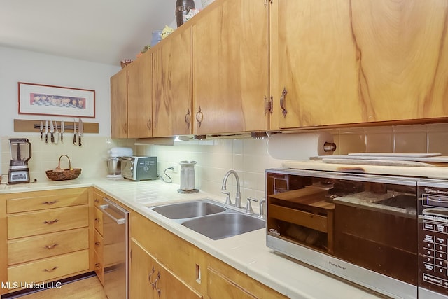 kitchen with sink, decorative backsplash, and stainless steel appliances