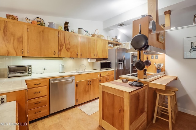 kitchen with stainless steel appliances, sink, vaulted ceiling, and decorative backsplash