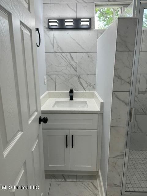 bathroom with a shower with door and vanity