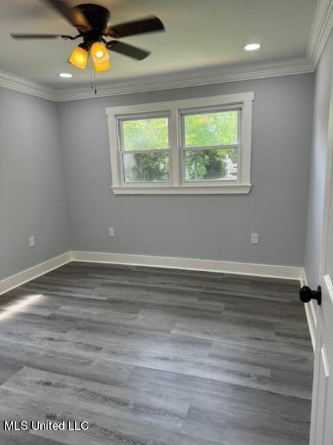 spare room with crown molding, dark hardwood / wood-style floors, and ceiling fan