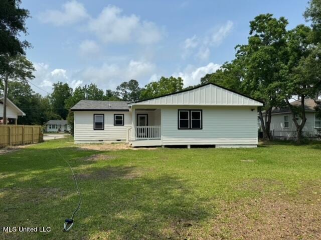 back of property featuring a lawn