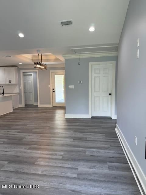 unfurnished living room featuring ornamental molding and dark hardwood / wood-style flooring