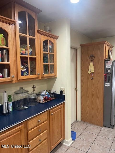 kitchen featuring light tile patterned floors and stainless steel fridge