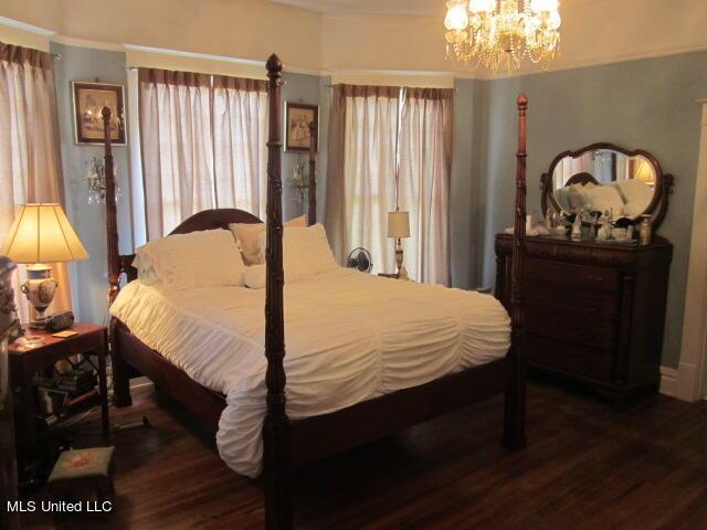 400 Crockett Ave, Greenwood, MS 38930 - bedroom with dark wood-type flooring and an inviting chandelier