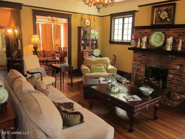 400 Crockett Ave, Greenwood, MS 38930 - living room with a fireplace, wood-type flooring, and a notable chandelier