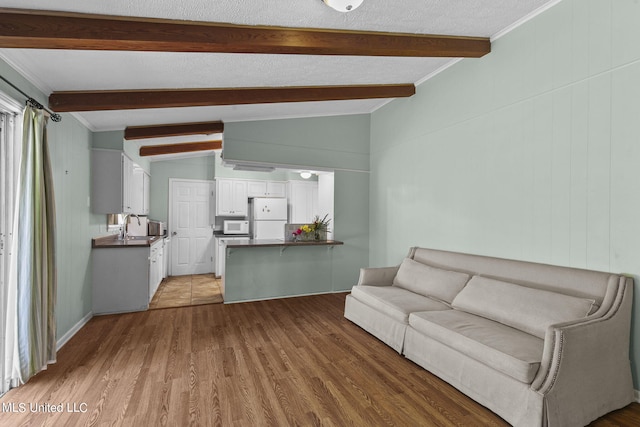 living room featuring crown molding, light hardwood / wood-style flooring, lofted ceiling with beams, and sink