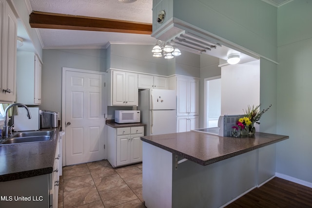 kitchen with sink, kitchen peninsula, white appliances, lofted ceiling, and white cabinets