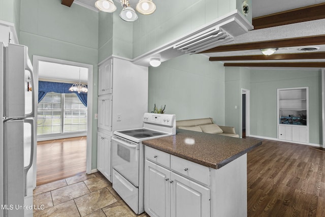 kitchen with white cabinets, vaulted ceiling with beams, white appliances, and light hardwood / wood-style floors