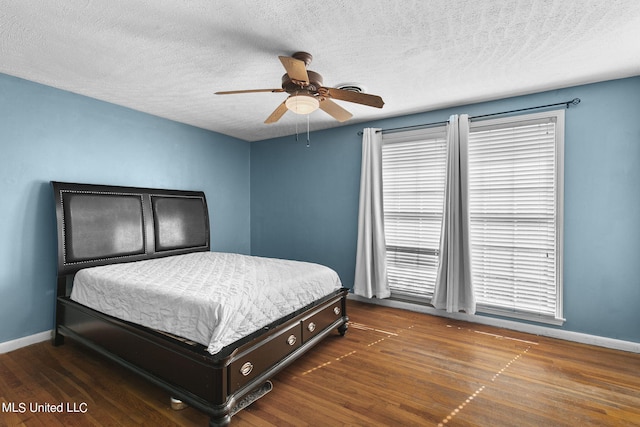 bedroom featuring a textured ceiling, dark hardwood / wood-style floors, and ceiling fan