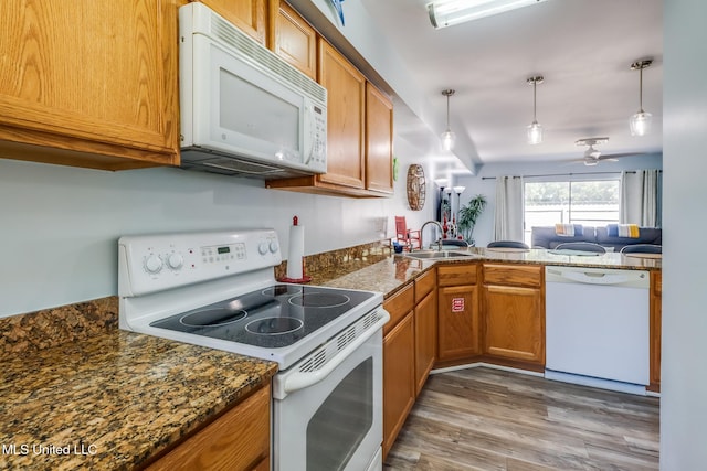 1664 Beach Blvd Unit 172, Biloxi, MS 39531 - kitchen with white appliances, brown cabinets, a peninsula, and light wood finished floors