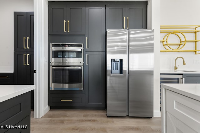 kitchen featuring sink, stainless steel appliances, and light hardwood / wood-style flooring