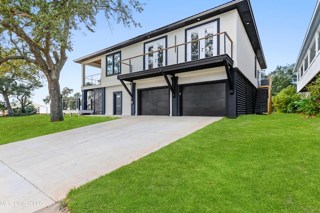 view of front of home with a front yard, a balcony, and a garage