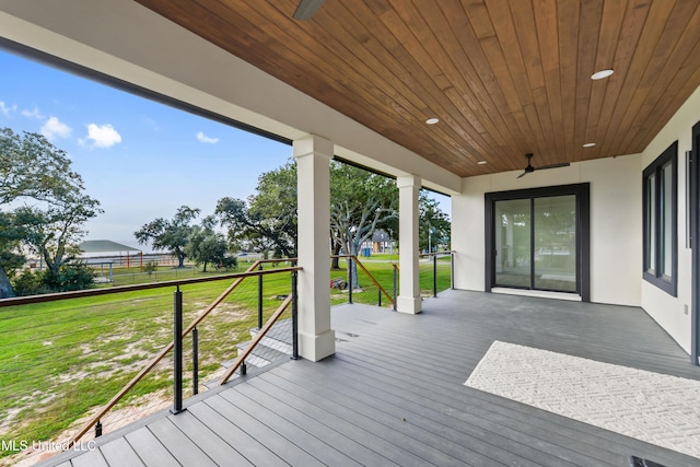 wooden terrace with ceiling fan and a yard