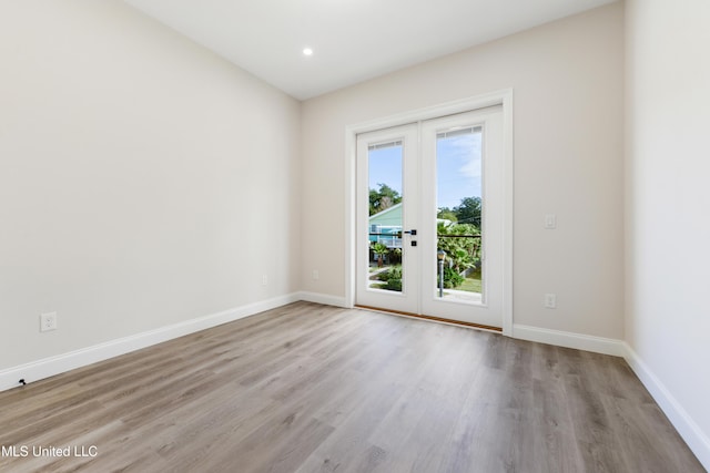 spare room with french doors and light hardwood / wood-style flooring