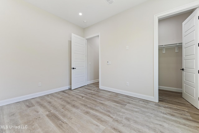 unfurnished bedroom with light wood-type flooring and a closet