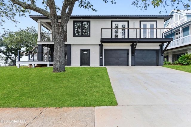 view of front of house featuring a garage, a balcony, a front yard, and french doors