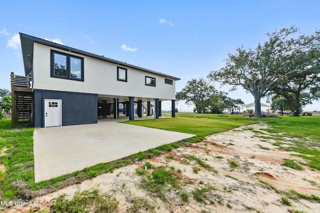 rear view of property with a carport and a lawn