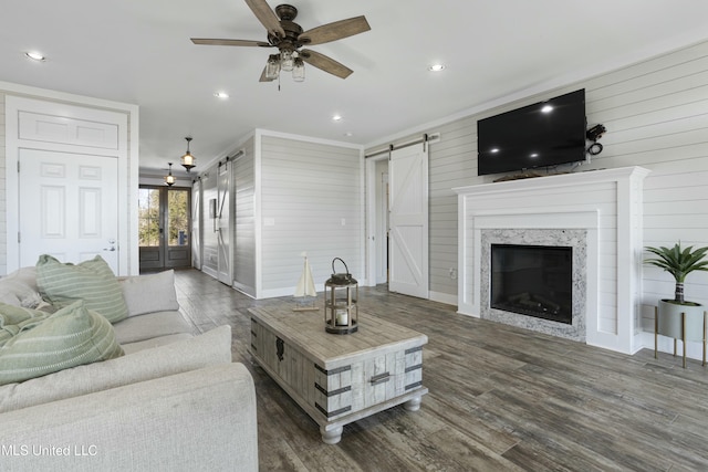 living room featuring recessed lighting, a barn door, a ceiling fan, and dark wood-style flooring